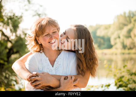 Mature mother hugging avec sa fille adolescente dans la nature en plein air aux beaux jours Banque D'Images