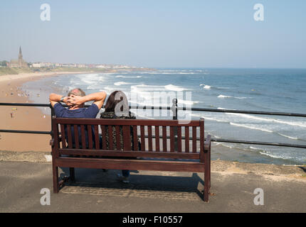 Couple assis regardant le Longsands, Tynemouth, North Tyneside, Angleterre, RU Banque D'Images