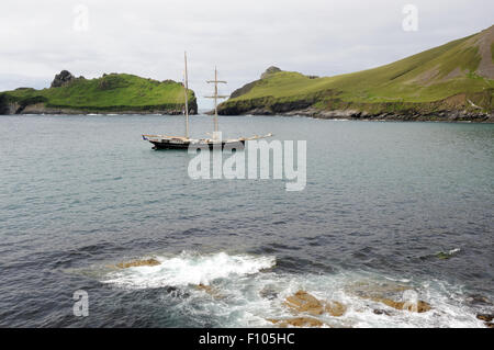 Le sloop Wylde Swan ancré dans la baie du Village avec l'île de Dun et le point le plus au sud de Hirta en arrière-plan. Hirta Banque D'Images