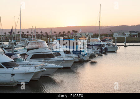 Droit de luxueux bateaux dans la marina avec montagnes en arrière-plan, pris au coucher du soleil Banque D'Images