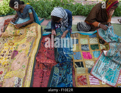 Le Rajasthan, Inde. Sawai Madhopur. Smiling women making tribal local tentures brodées traditionnelles. Banque D'Images