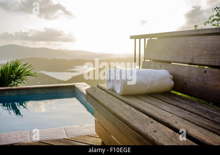 Les serviettes blanches roula sur un banc en bois avec vue sur la mer des Caraïbes Banque D'Images