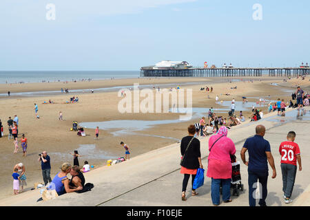 Les vacanciers sur la plage de sable en face de la jetée nord de Blackpool Banque D'Images