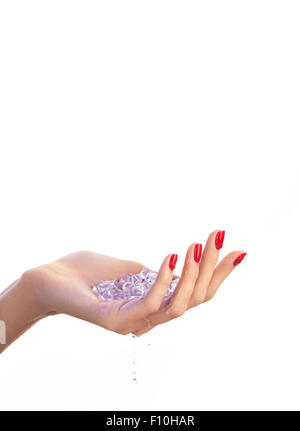La main féminine avec vernis à ongles rouge, bleu des cubes de glace à l'intérieur de lui et des gouttes d'eau, isolé sur fond blanc Banque D'Images