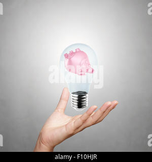 Part montrant tirelire avec ampoule électrique comme concept Banque D'Images