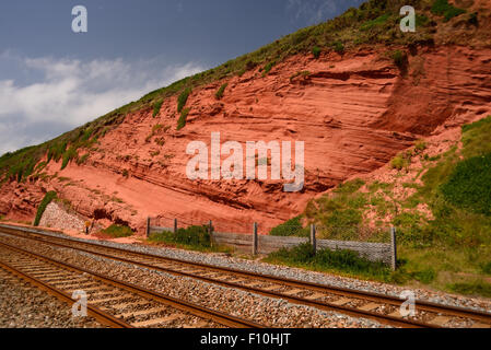 Falaises de grès rouge à côté de la ligne de chemin de fer côtière. Banque D'Images