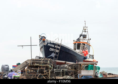 Un bateau de pêche au travail échoués sur Deal, Kent avec l'ensemble de l'attirail de pêche autour d'elle prise sur un jour d'été pluvieux Banque D'Images