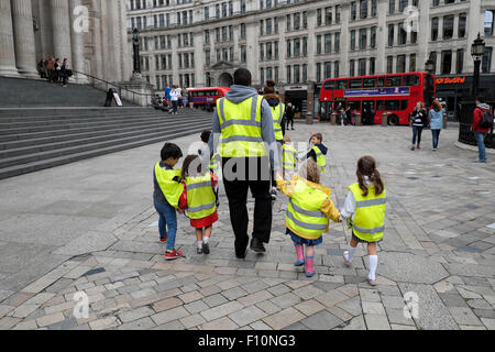 Enfants et enfants en garderie après avoir traversé la rue ville, vue arrière, à pied devant la cathédrale St Pauls, Londres, Royaume-Uni KATHY DEWITT Banque D'Images