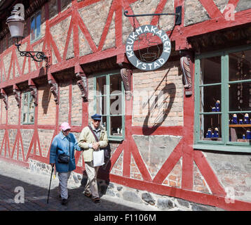 Olderly couple marche dernières magasin de poterie à colombages à Ystad à Skane, Suède. Homme porte cap nautique. Banque D'Images