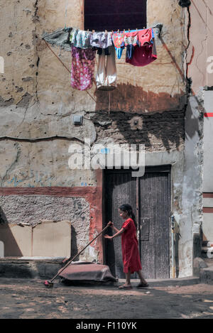 Balayer au sol jeune fille dans la vieille ville arabe d'Assouan, Egypte, Afrique du Sud Banque D'Images