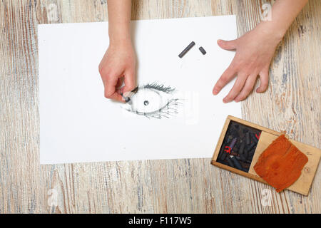 L'artiste attire l'oeil au fusain sur papier. La notion de créativité. Banque D'Images