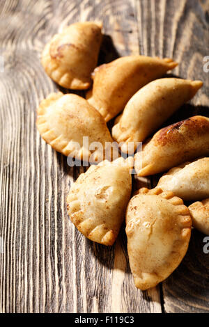 Empanadas colombiennes au plat sur table en bois. Galettes farcies salé également connu sous le nom de la pate,pastel ou pirozhki Banque D'Images