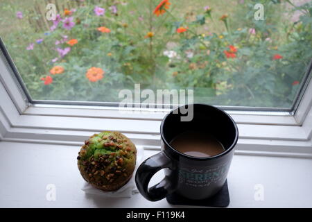 Profiter de café et un muffin en face d'une belle vue sur le jardin. Banque D'Images