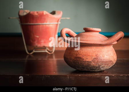 Ancien pot en argile et cuisinière sur une table en bois. Banque D'Images