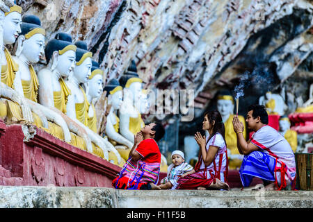 Asian family praying at temple Bouddha Banque D'Images