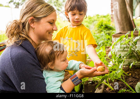 Mère et enfants admirant le jardin de légumes Banque D'Images