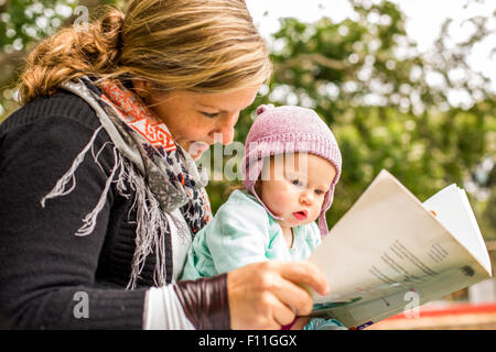 Mère Et Bébé Lisant Un Livre Dans La Chambre Sombre. Maman Et Enfant Lisent  Des Livres Avant L'heure Du Coucher. Famille Dans La Soirée. Chambre  D'enfant Intérieur Avec Lampe De Nuit Et