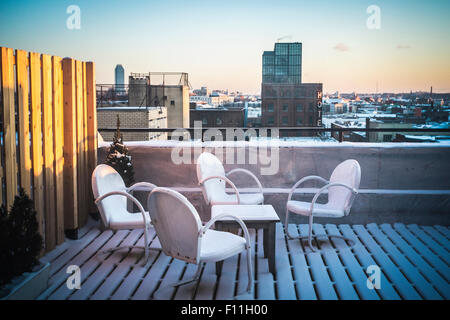Les meubles de patio dans la neige on urban rooftop, New York, New York, United States Banque D'Images