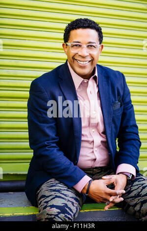 Mixed Race businessman sitting at porte de chargement Banque D'Images