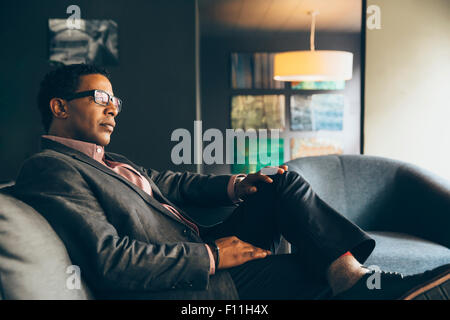 Mixed Race businessman sitting in office lobby Banque D'Images