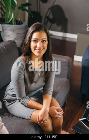 Mixed Race businesswoman sitting in office lobby Banque D'Images