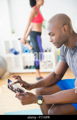 Man using digital tablet in gym Banque D'Images