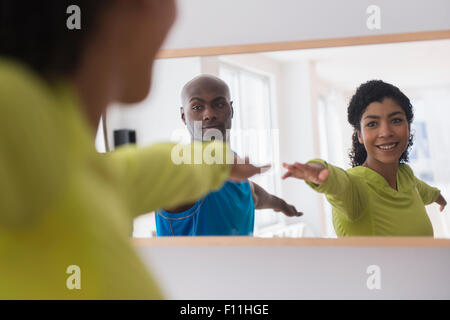 Couple practicing yoga in mirror Banque D'Images