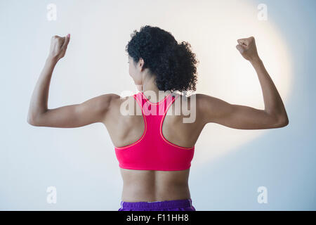 Mixed Race woman flexing muscles Banque D'Images