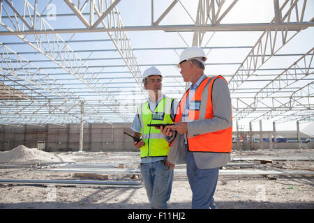 Young architects talking at construction site Banque D'Images