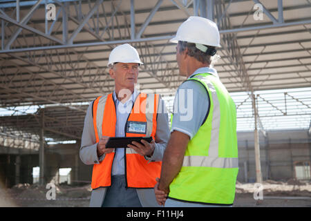 Young architects talking at construction site Banque D'Images