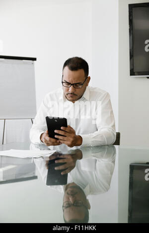 Hispanic businessman using digital tablet in office Banque D'Images