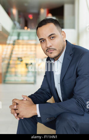 Hispanic businessman sitting in hotel lobby Banque D'Images