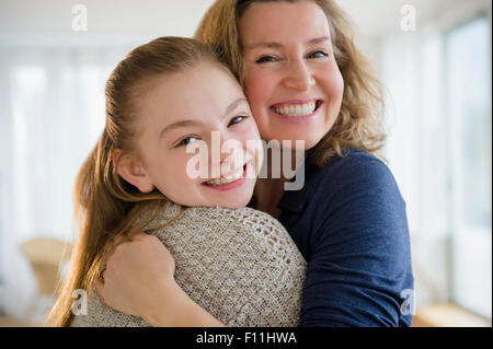 Caucasian mother and daughter hugging in living room Banque D'Images