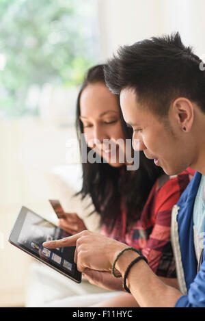 Close up of couple shopping online on digital tablet Banque D'Images