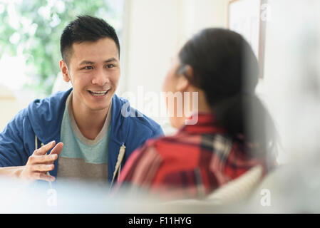 Couple talking on sofa in living room Banque D'Images