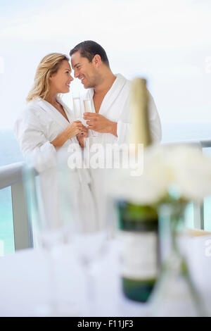 Couple drinking champagne on balcon table Banque D'Images