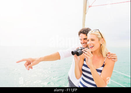 Couple à la recherche de pont de bateau avec des jumelles Banque D'Images