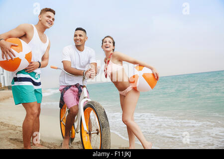 Smiling friends talking on beach Banque D'Images