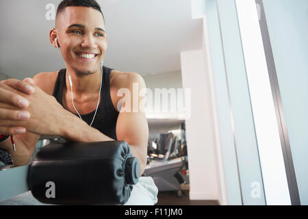 Black man smiling sur machine d'exercice dans la salle de sport Banque D'Images