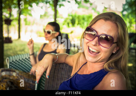 Les femmes de race blanche assis dans des chaises de jardin Banque D'Images