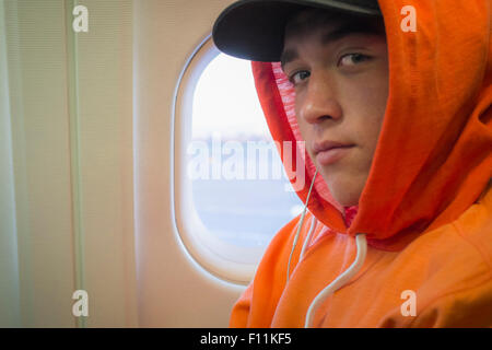 Caucasian man wearing hoodie on airplane Banque D'Images