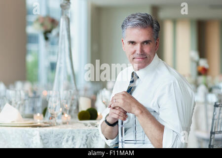 Caucasian businessman smiling in salle à manger vide Banque D'Images