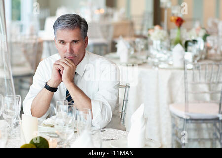 Caucasian businessman sitting in empty salle à manger Banque D'Images