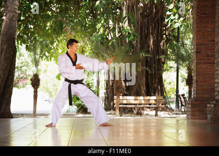 Hispanic man practicing martial arts on patio Banque D'Images