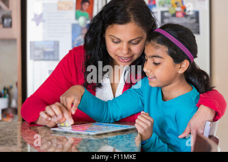 Indian mother and daughter using digital tablet Banque D'Images