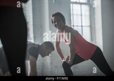 Les athlètes qui s'étend les jambes dans la salle de sport Banque D'Images