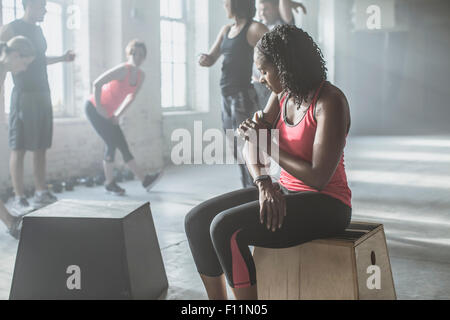 Athlète listening to mp3 player in gym Banque D'Images