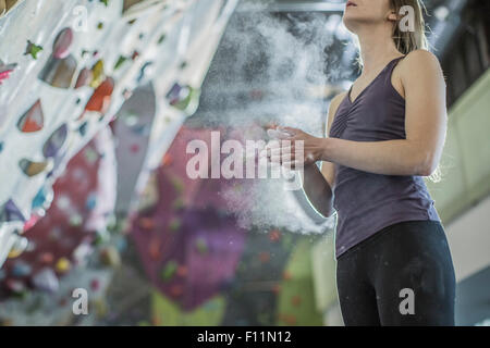 Farinage athlète ses mains à rock wall in gym Banque D'Images