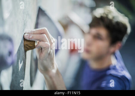 Close up of sportif climbing rock wall in gym Banque D'Images