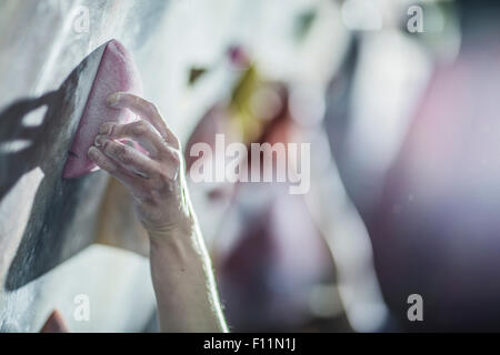 Close up of sportif climbing rock wall in gym Banque D'Images